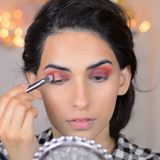 A girl applying eyeshadow on her eyelids using Vasanti Stubby Contour Eyeshadow Brush
