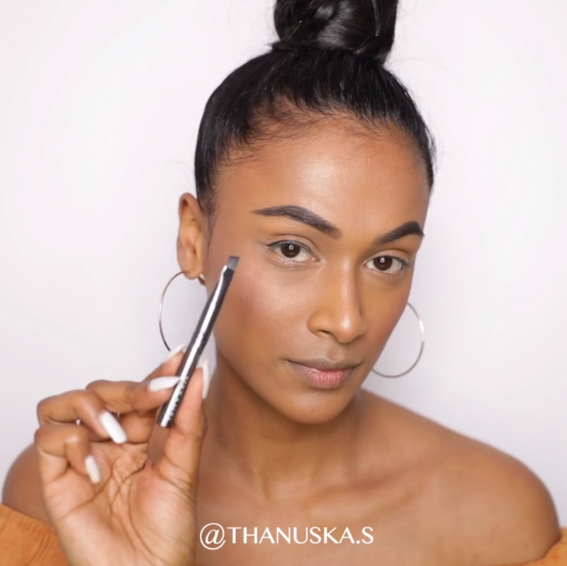 A girl using Vasanti Stubby Liner Brow Brush on her brows